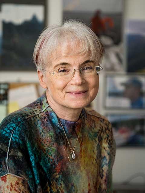 Malgorzata Peszynska smiling while wearing a multicolored shirt, mixed of teals and tans